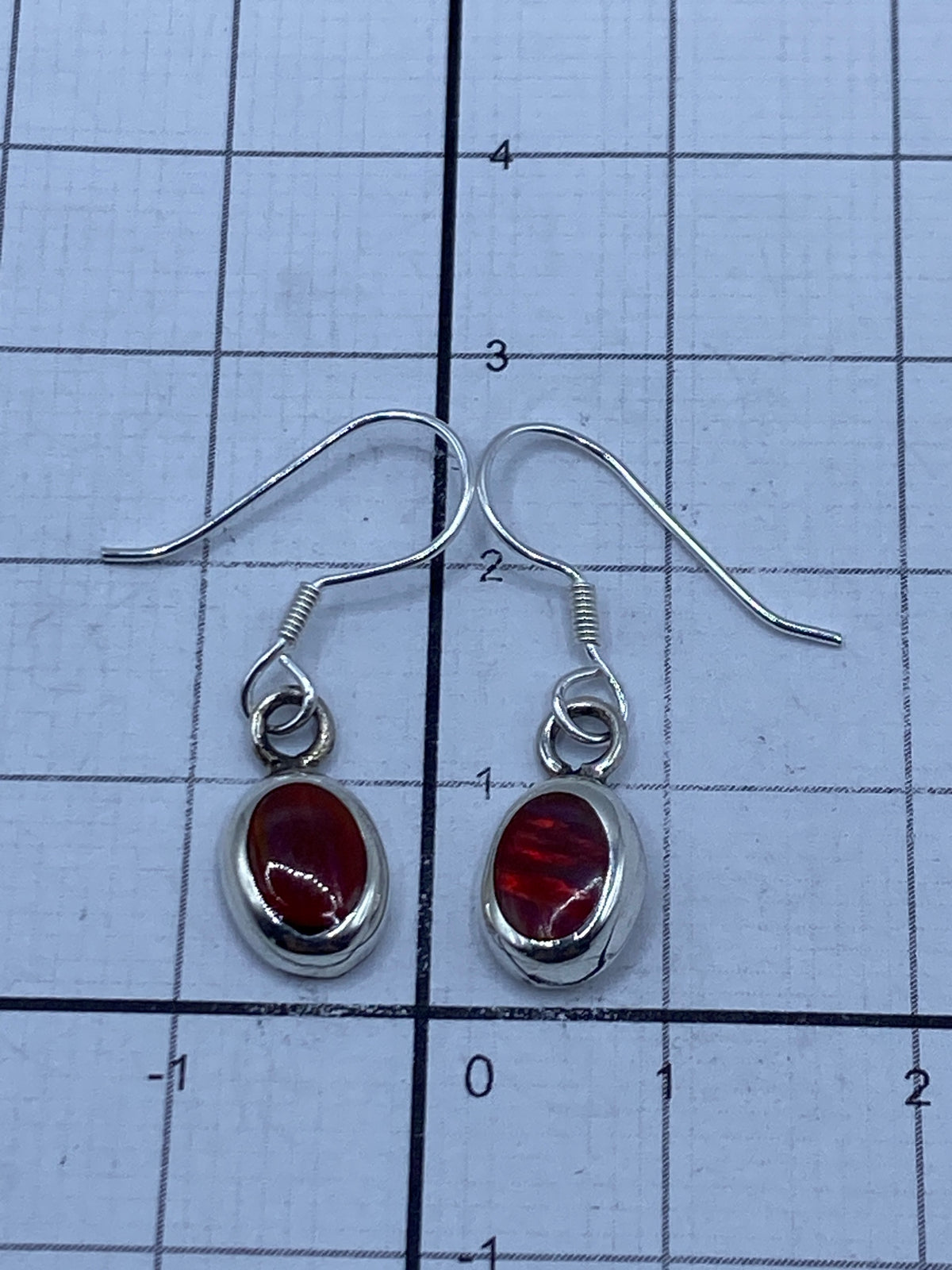 Aretes en estuche con cierre, mostrando el Quinto 925 grabado en la parte trasera