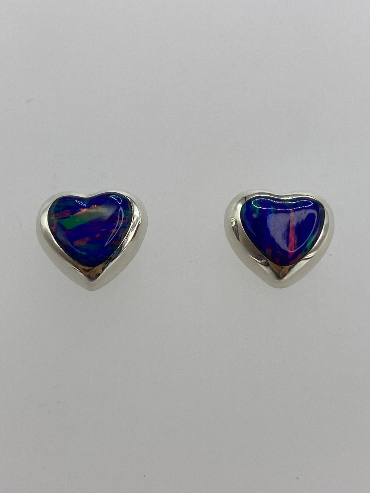 Aretes de ópalo morado — detalle del engaste y el brillo del color