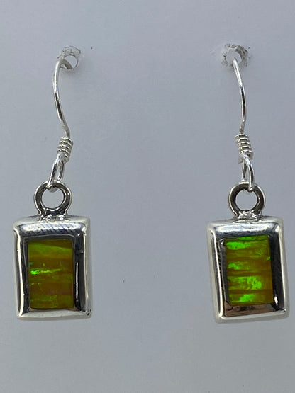 Aretes de ópalo de fuego sobre fondo blanco con el sello 925 visible en la plata