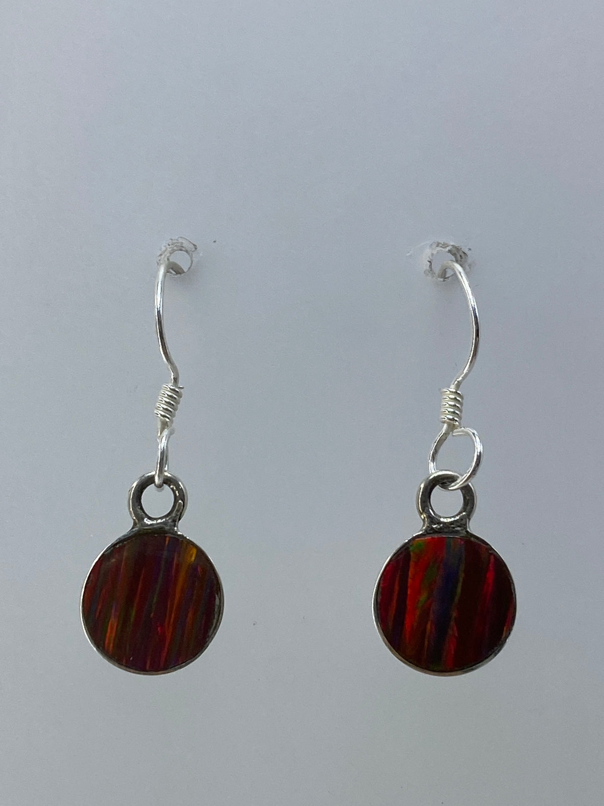 Par de aretes de plata con ópalo de fuego multicolor que refleja tonos rojos, naranjas y verdes