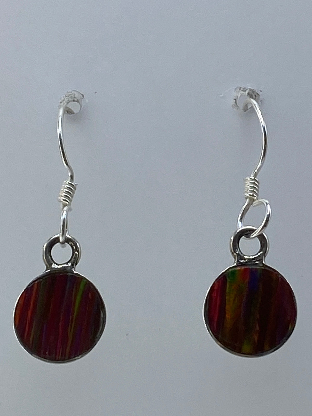 Aretes colgando sobre regla de centímetros, largo 2.5 cm visible
