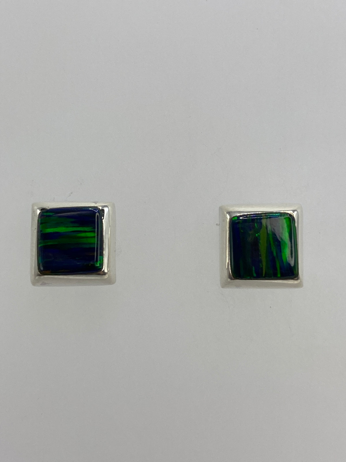 Par de aretes de plata 925 con ópalo de fuego verde, sobre fondo blanco