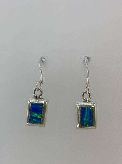 Aretes vistos de frente mostrando la piedra verde limon engastada en marco de plata