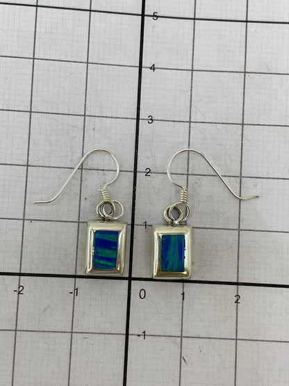 Aretes sobre regla de medicion mostrando los 2.5 cm de largo