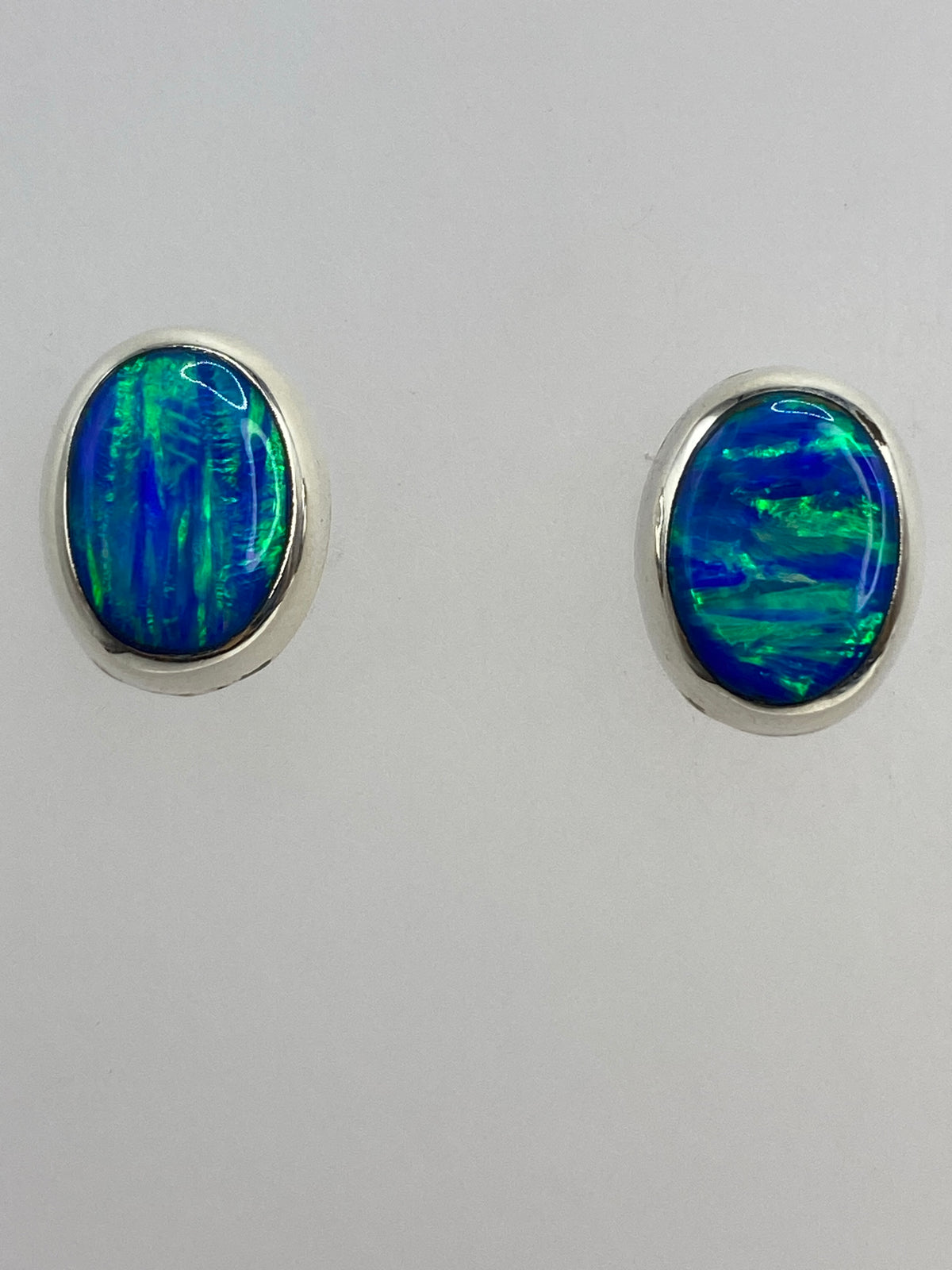 Aretes al lado de una regla mostrando el largo de 1.4 cm