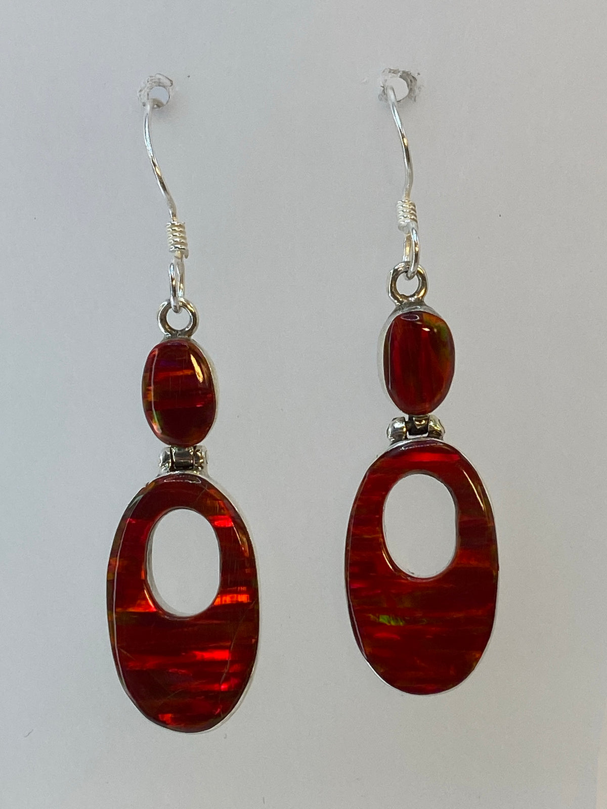 Detalle del engaste a mano del opalo rojo en los aretes de plata