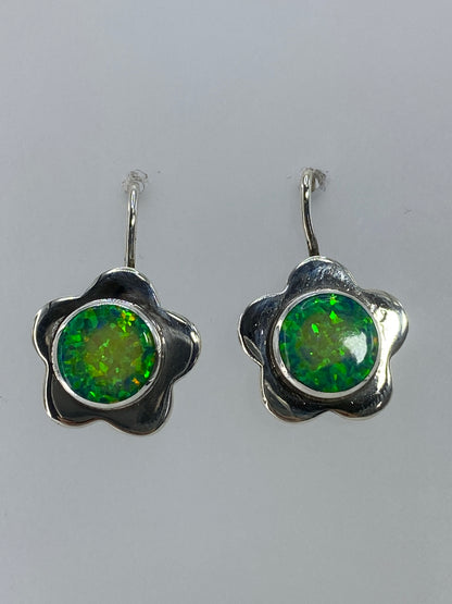 Aretes colgando mostrando el brillo verde limón del ópalo de fuego