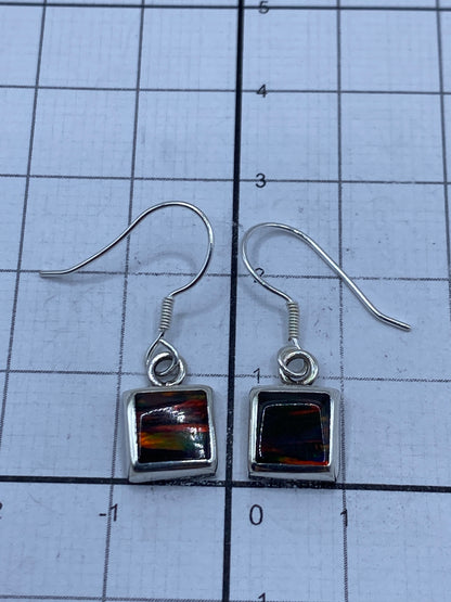 Aretes en estuche azul mostrando peso de 1.4 gramos en báscula