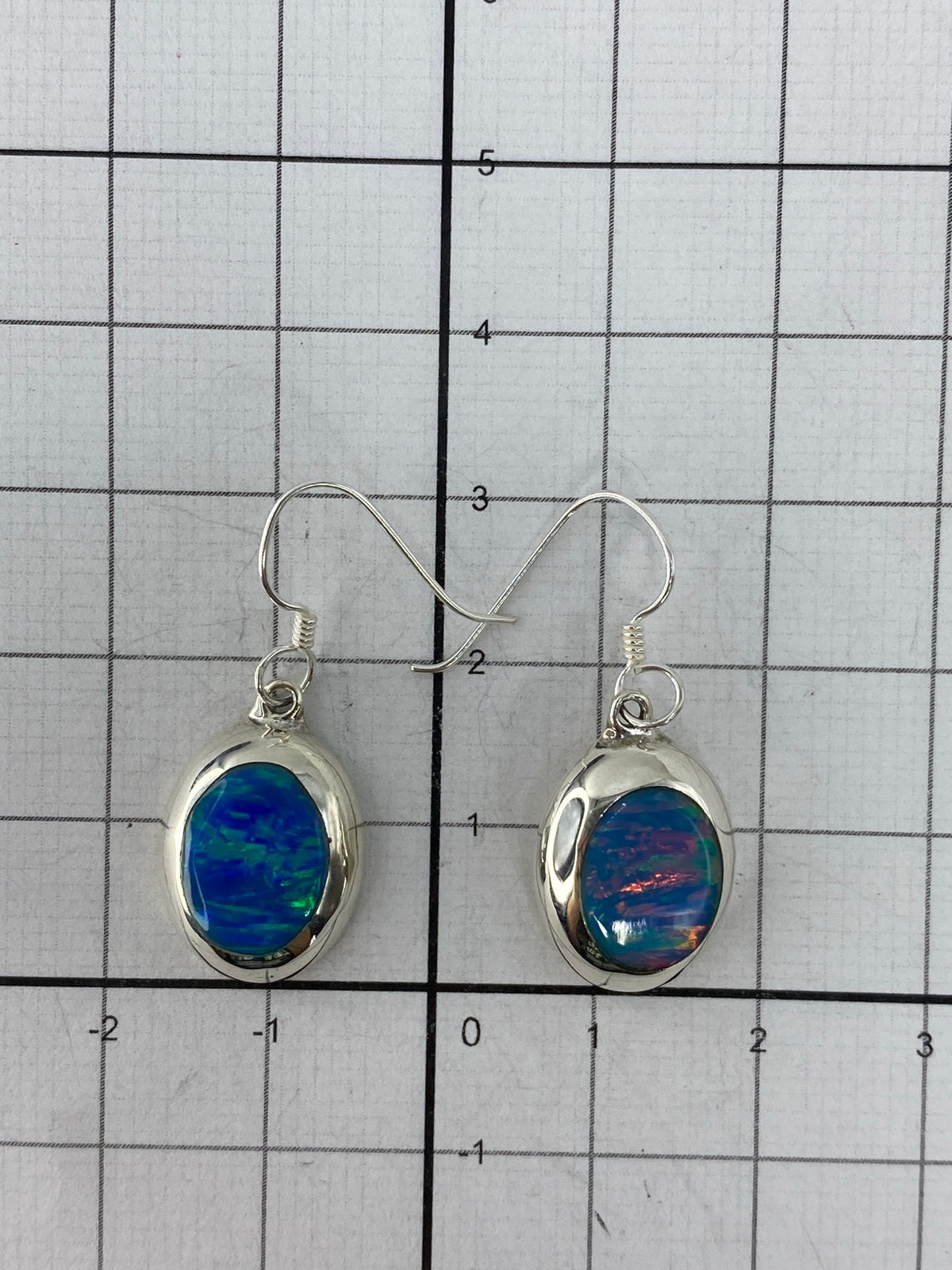 Aretes colgando de gancho de plata mostrando el Quinto 925