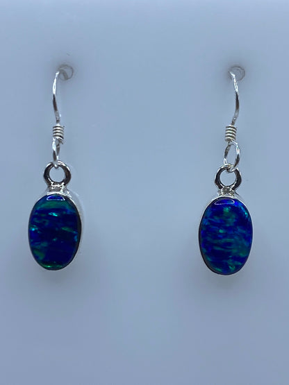 Par de aretes de plata 950 con ópalo de fuego azul, gancho de plata, fotografiados en fondo blanco