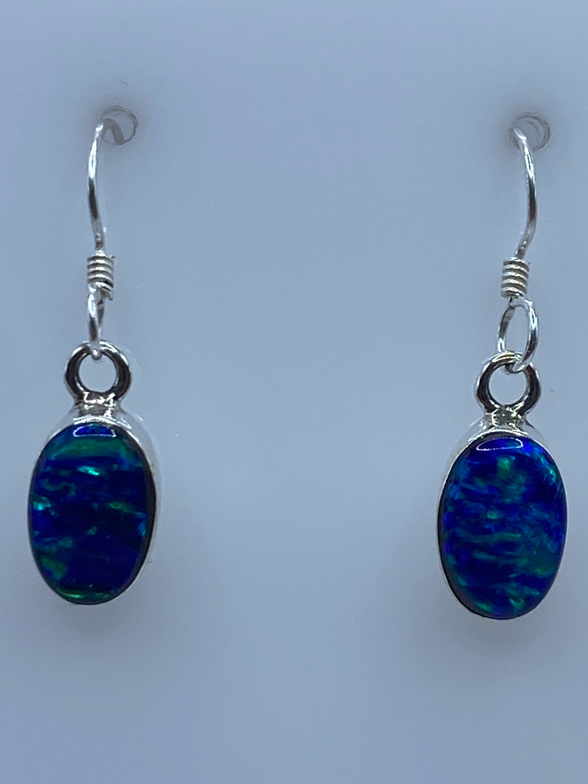 Medida de los aretes en escala con regla: largo 2.5 cm, ovalados y delicados