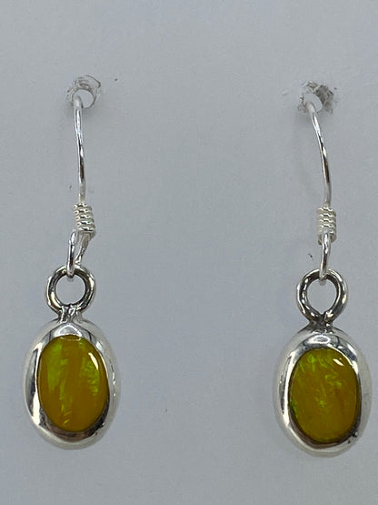 Aretes puestos en la oreja, mostrando largo de 2.3 cm y brillo del ópalo