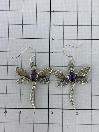 Aretes colocados en gancho de plata con vista de la incrustación a mano