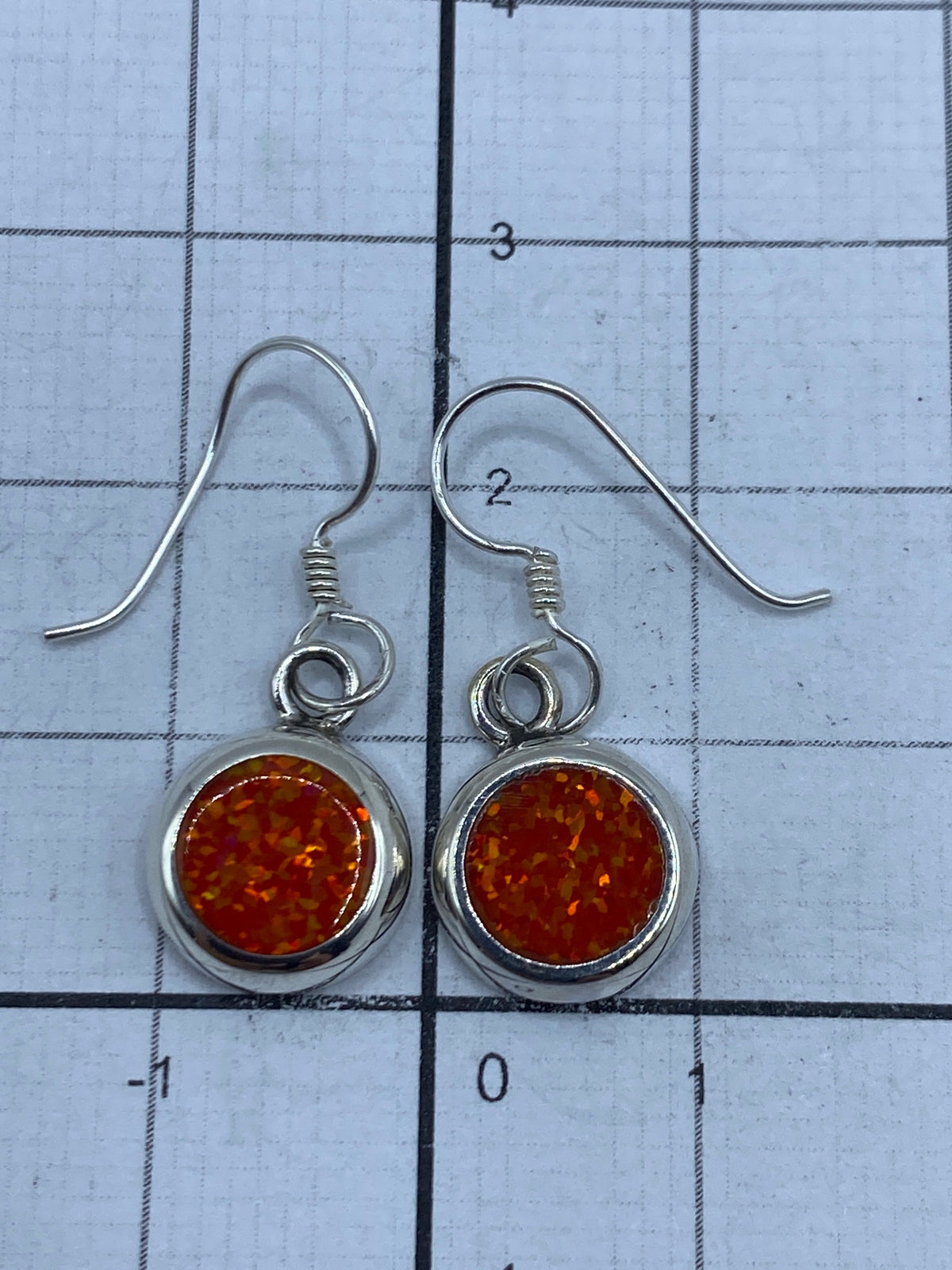 Los aretes de ópalo sobre una escala para confirmar tamaño y peso (1.6 g el par)