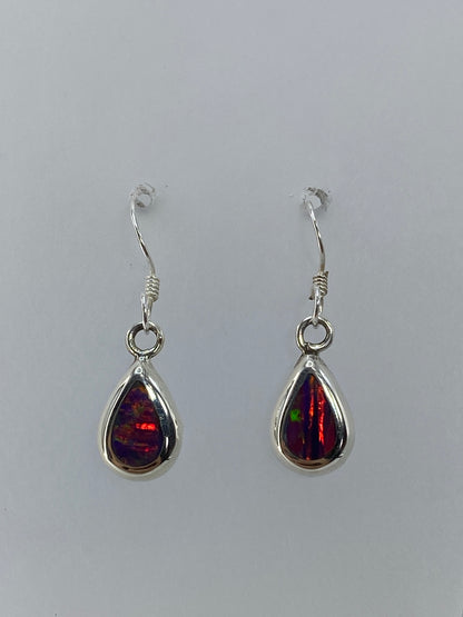 Aretes ópalo de fuego mostrando el brillo rojo y naranja intenso