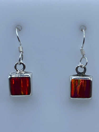 Par de aretes de plata con opalo de fuego rosa engastado, vista frontal del dije cuadrado