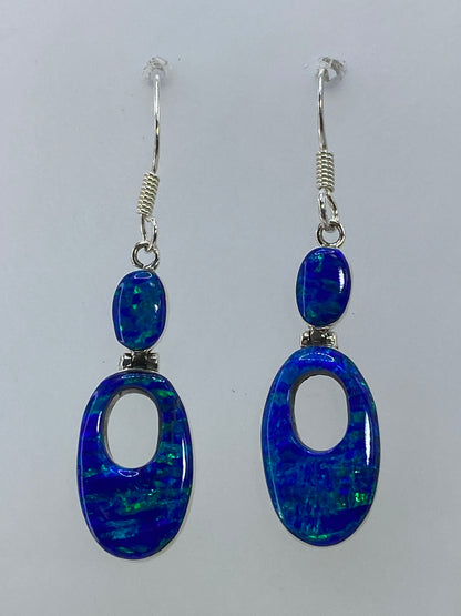 Aretes ópalo de fuego multicolor en plata 950, colgando en par sobre fondo blanco
