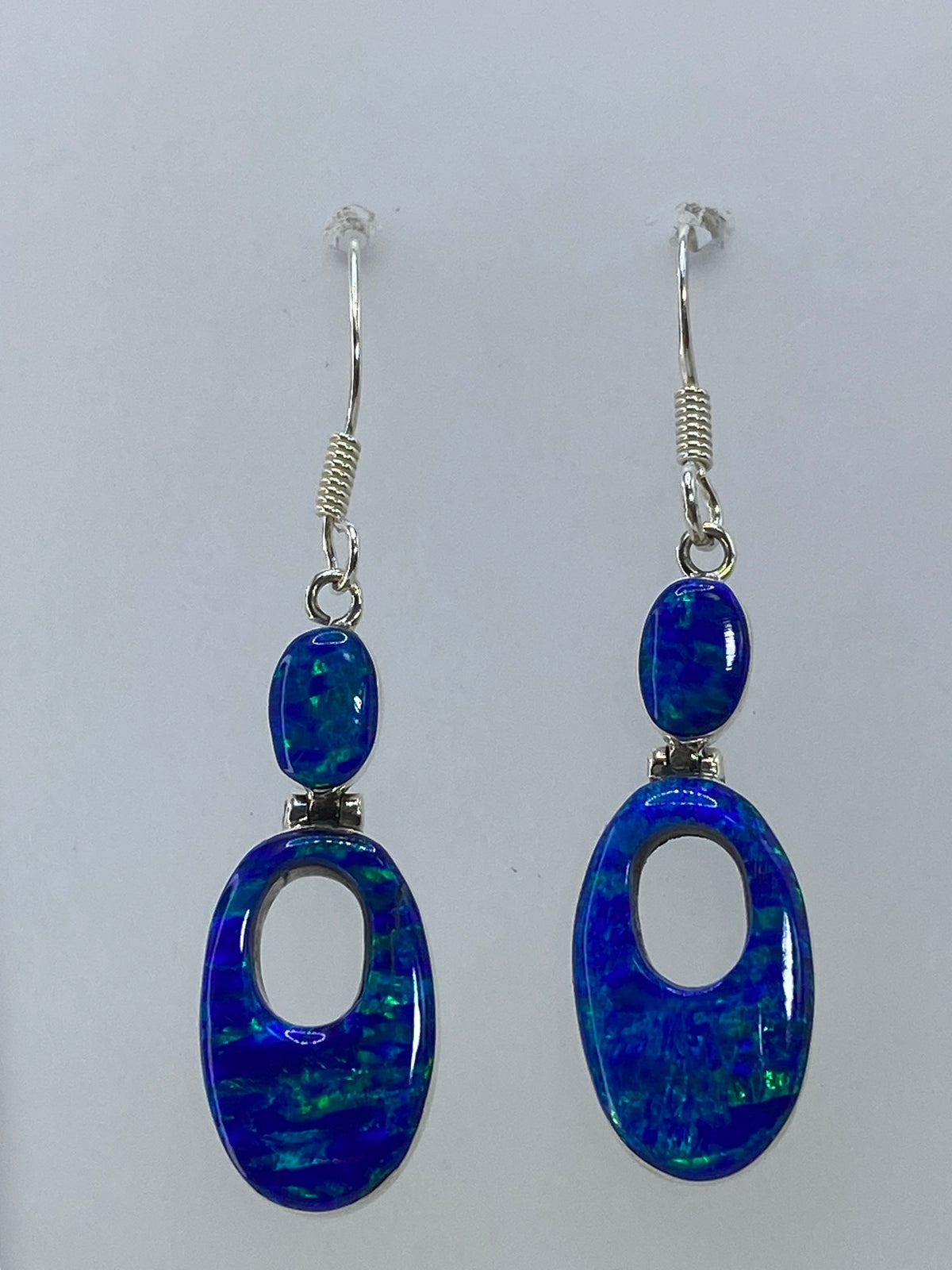 Detalle del ópalo de fuego mostrando reflejos azules y verdes en diseño ovalado calado