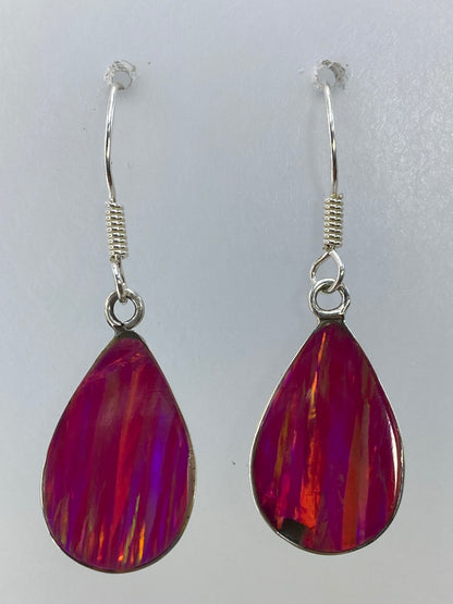 Aretes colgando, mostrando el brillo translúcido y los reflejos del ópalo rosa