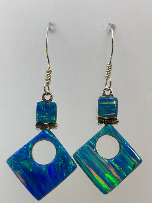 Aretes de plata 950 con ópalo de fuego multicolor sobre fondo blanco