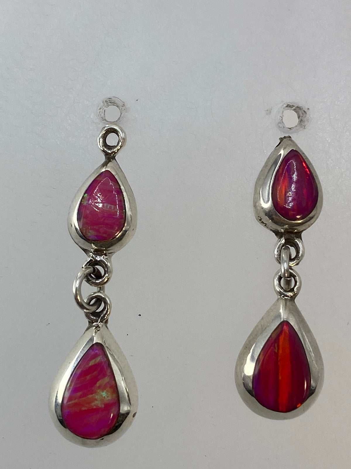 Detalle del engaste a mano del ópalo de fuego en cada arete