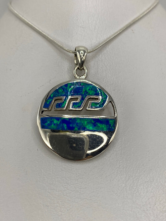 Dije de plata 950 con ópalo de fuego azul colgando de cadena de plata