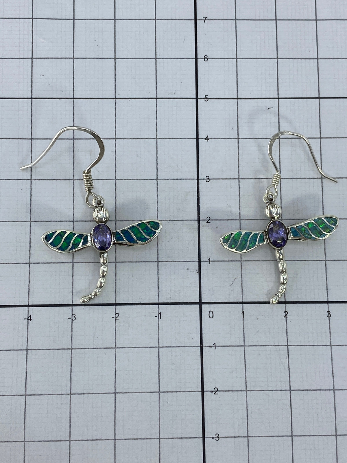 Aretes libelula en la mano mostrando el brillo del Opalo de Fuego verde