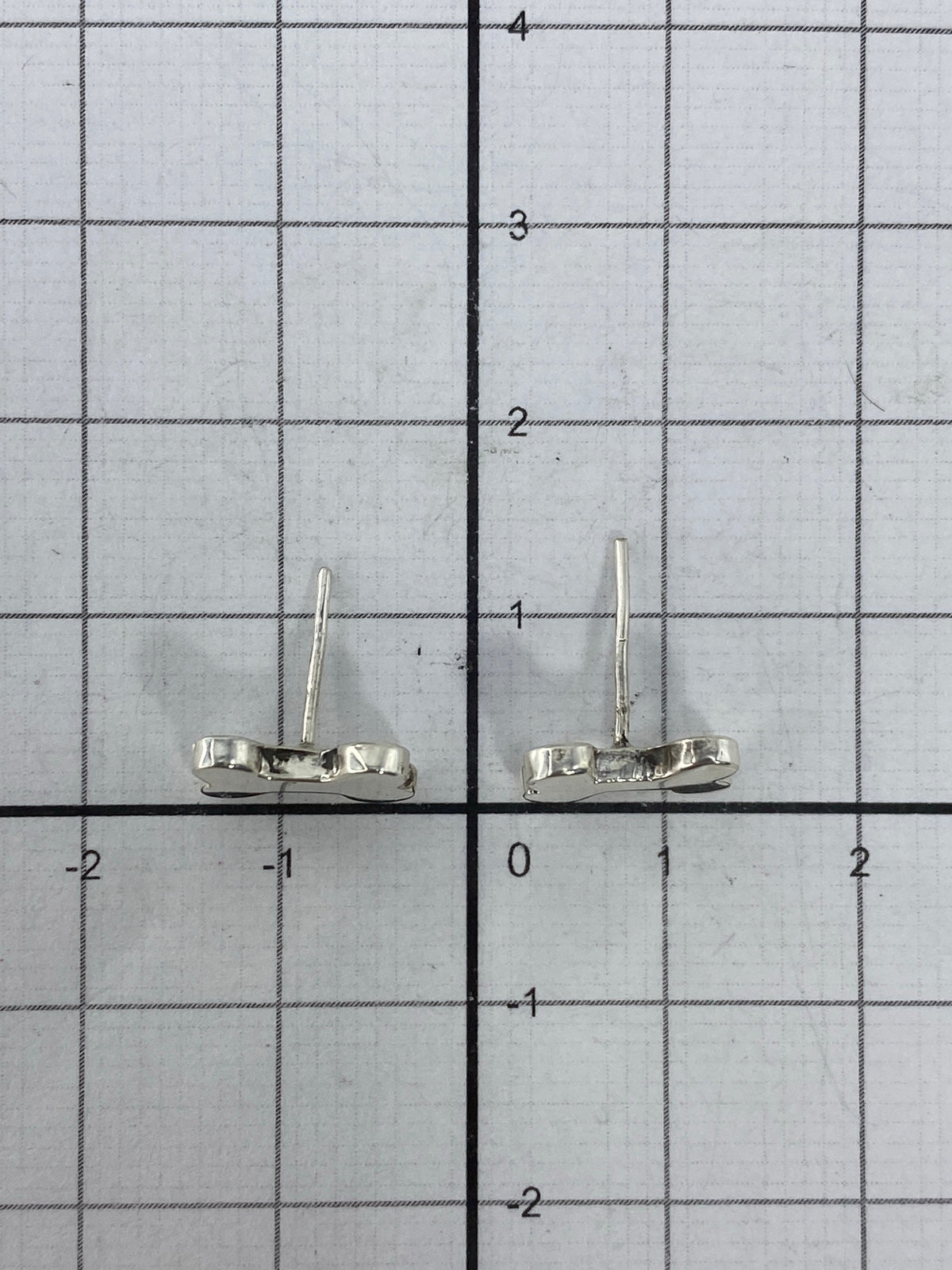 Aretes de cartoneado sobre fondo blanco mostrando el Quinto 925