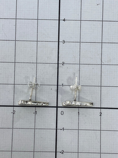 Aretes en mano mostrando el tamaño real de 1.2 cm de largo