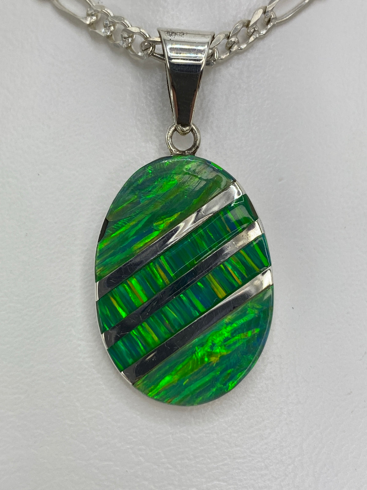 Detalle del ópalo de fuego verde mostrando los reflejos y la incrustación a mano en plata 950