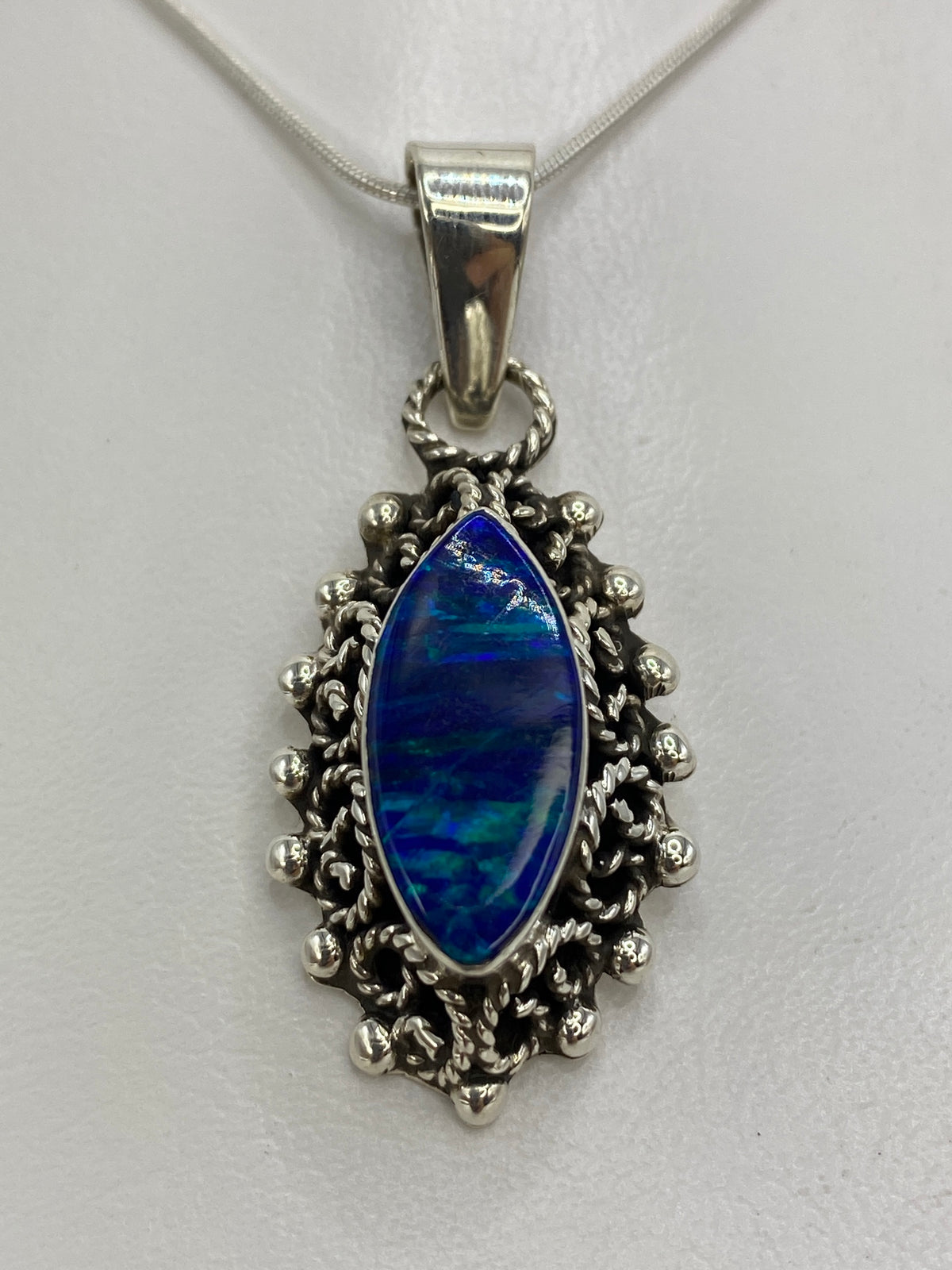 Detalle del ópalo de fuego azul mostrando el cambio de tonos en el engaste de plata