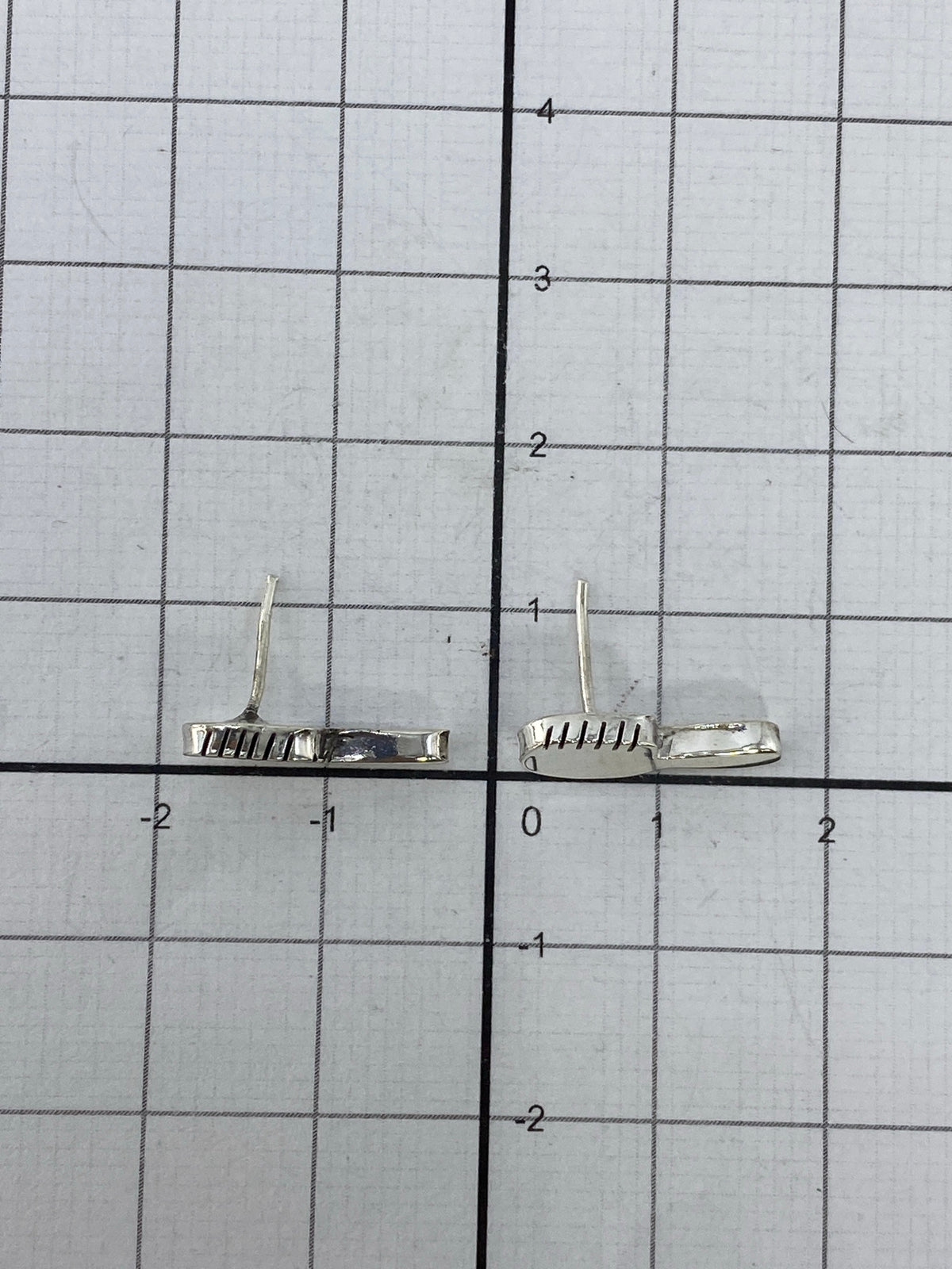 Aretes en la mano mostrando su tamaño diminuto y ligereza