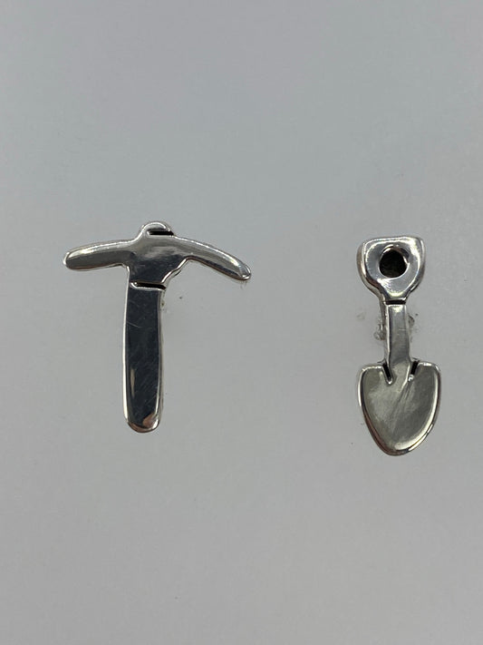 Par de aretes de plata cartoneado en la mano, vista frontal