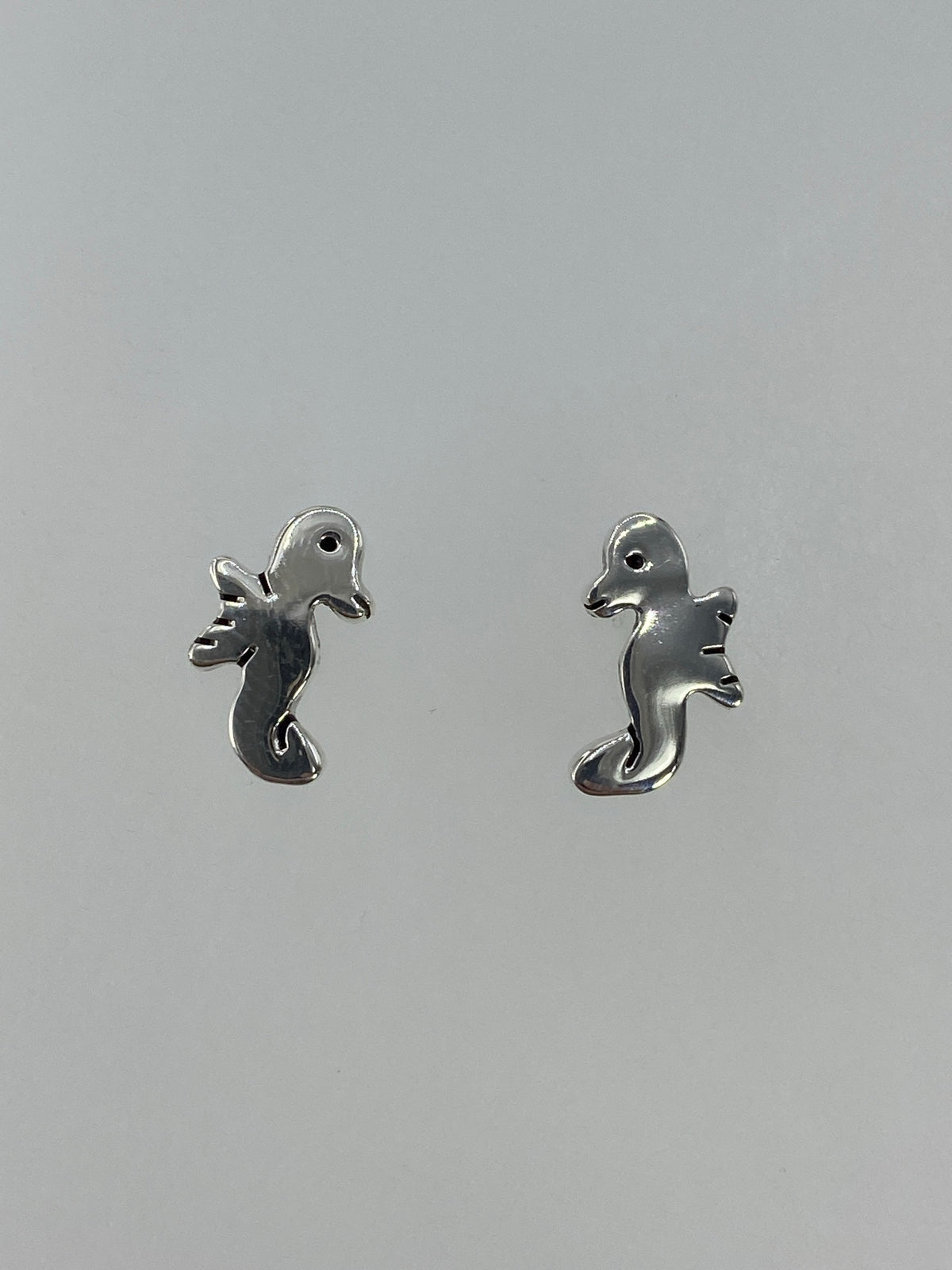 Arete individual de plata cartoneado mostrando el volumen y detalle del caballito