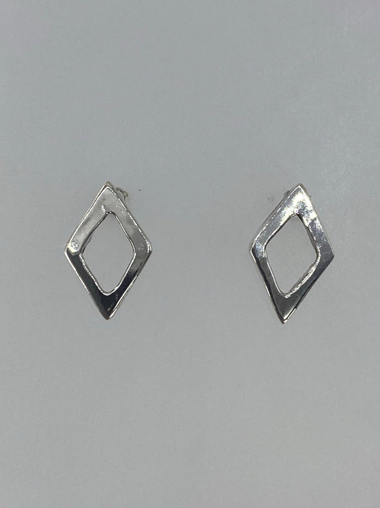 Aretes de plata cartoneado minimalista vistos de frente sobre fondo gris