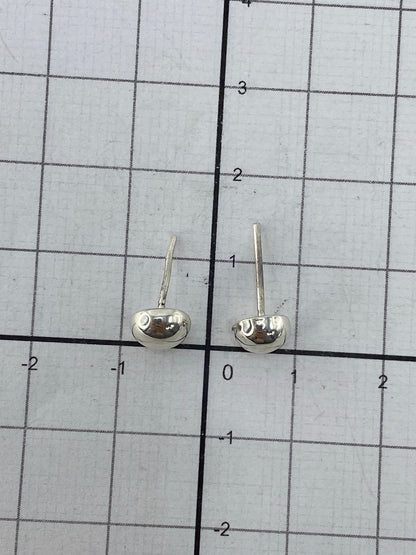 Aretes puestos en oreja, mostrando el largo de 1.5 cm y el cierre de poste