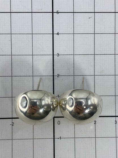 Aretes sobre fondo blanco con escala de medida mostrando 2 cm de largo