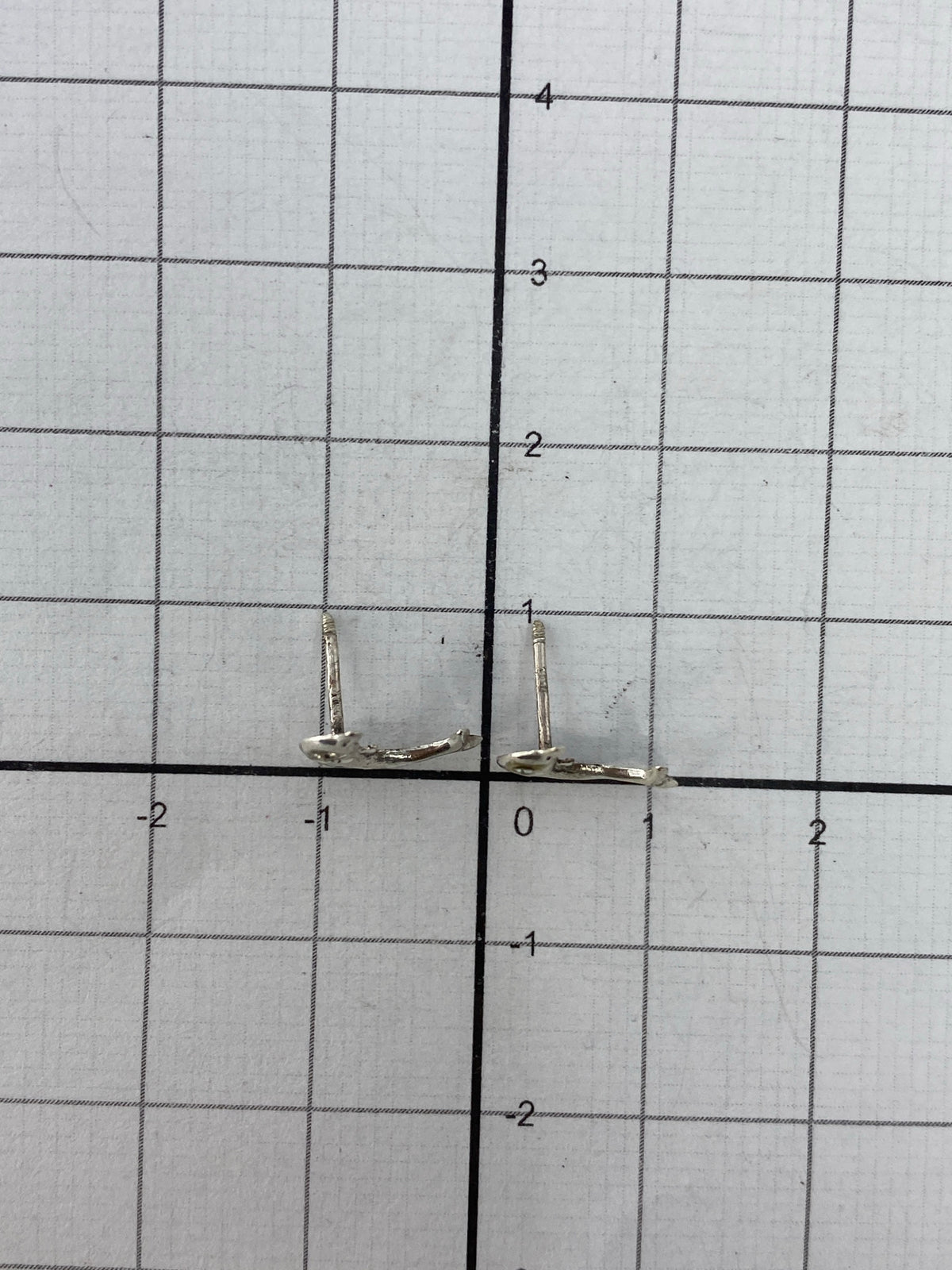 Los dos aretes juntos en escala con regla de centímetros