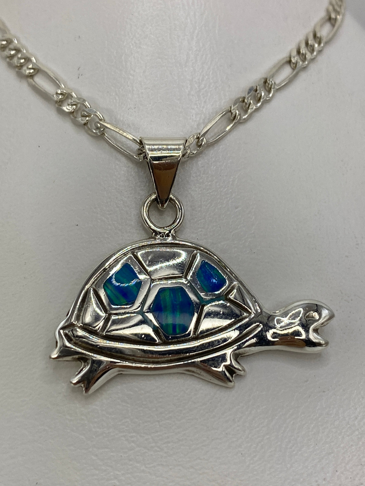 Dije tortuga en plata 925 con ópalo de fuego azul sobre cadena figaro