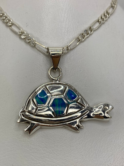 Dije tortuga en plata 925 con ópalo de fuego azul sobre cadena figaro