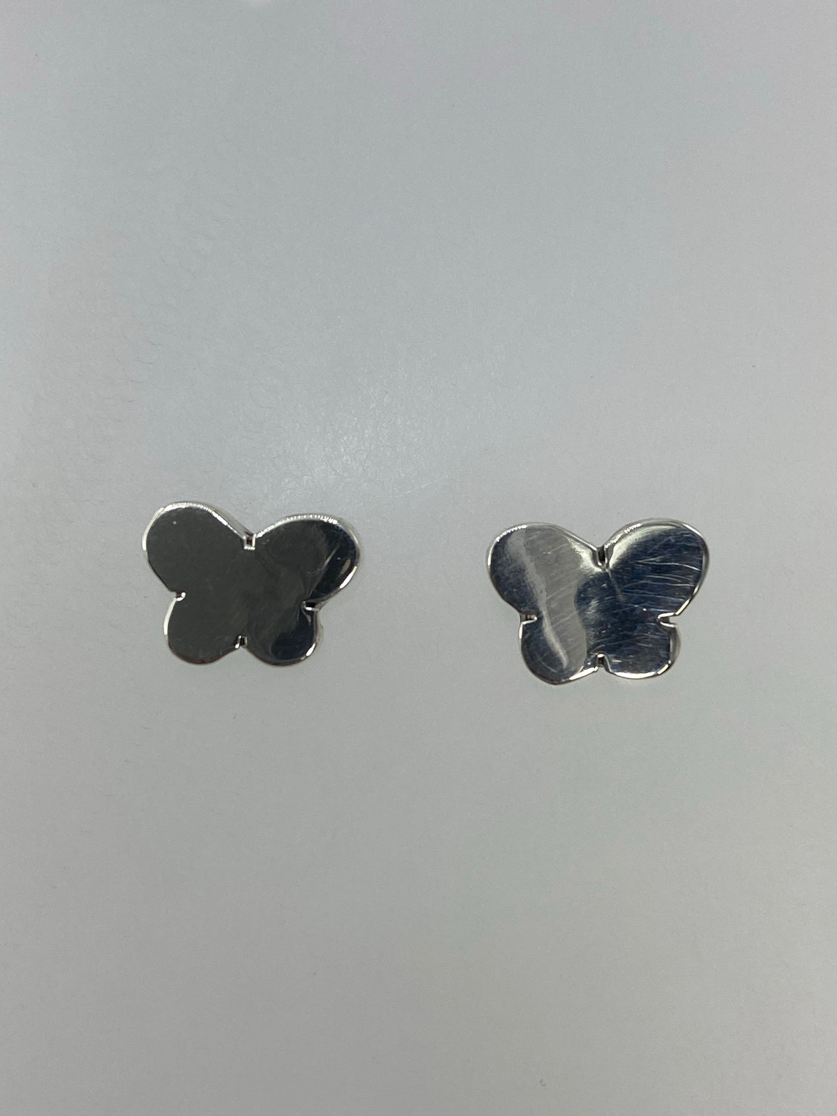 Detalle del cartoneado en plata 925, vista frontal de un arete mariposa