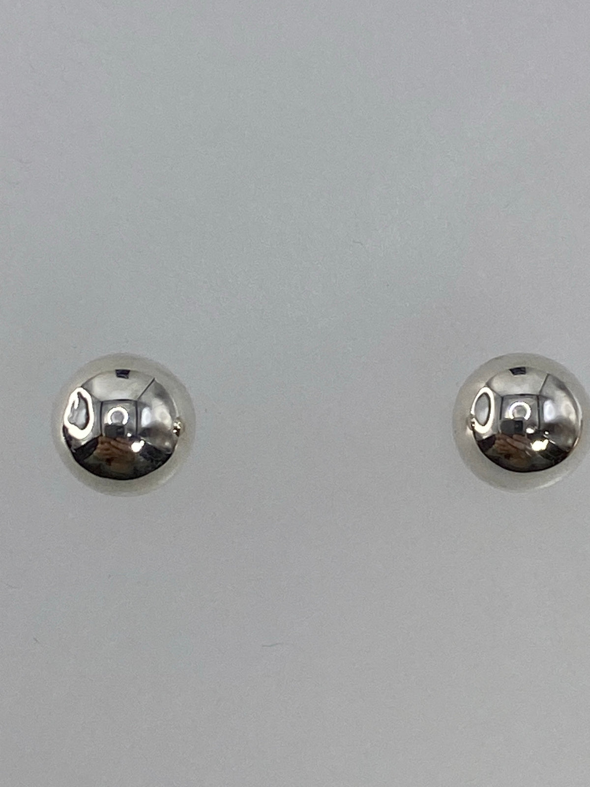 Aretes sobre escala digital mostrando el peso mínimo de 0.7 gramos el par