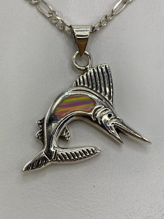 Dije de plata en forma de pez saltarín con ópalo de fuego rosa, colgado en cadena sobre fondo blanco