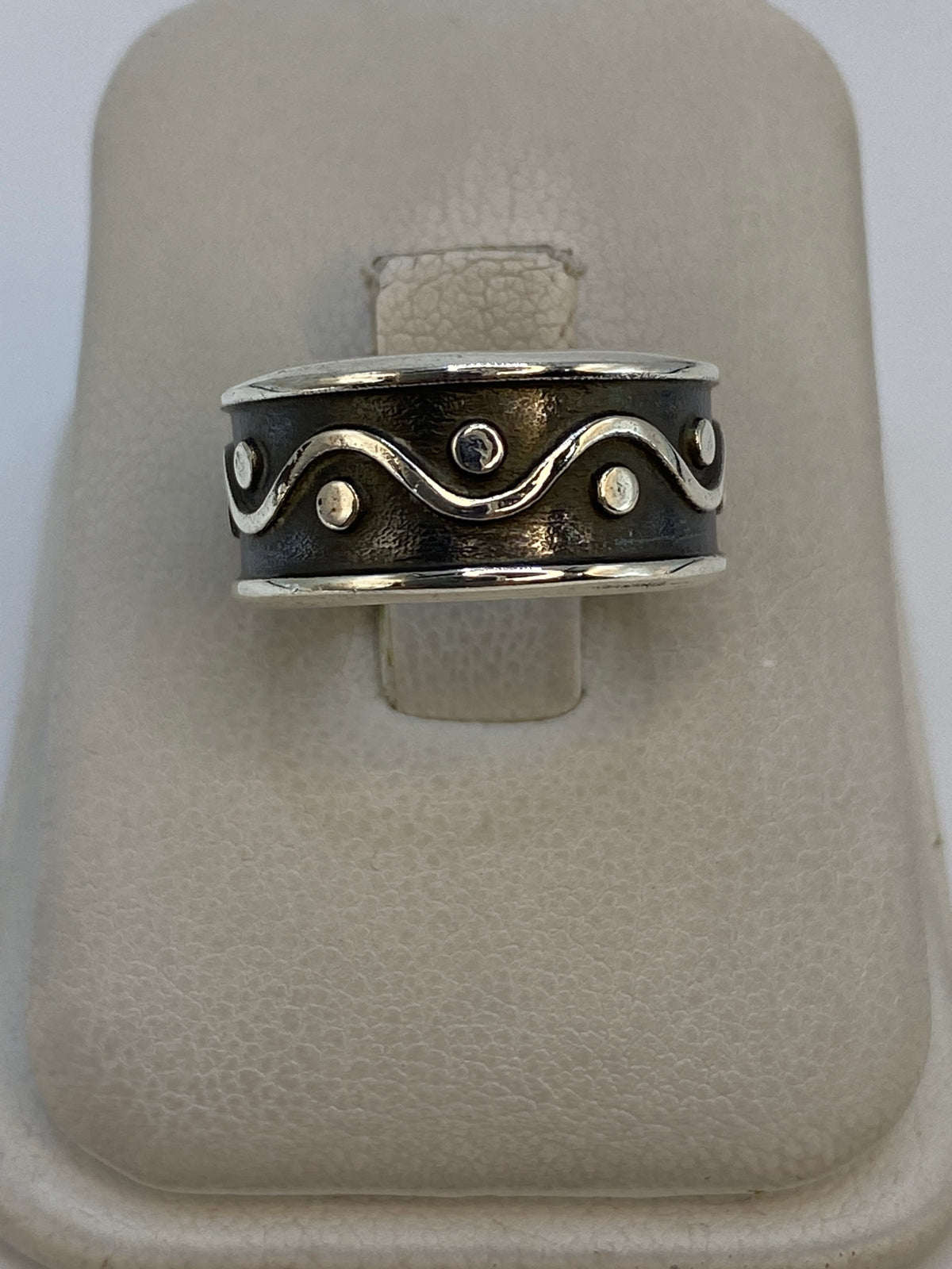 Anillo de plata 925 repujado en diseño geométrico con ondas y círculos, visto desde arriba