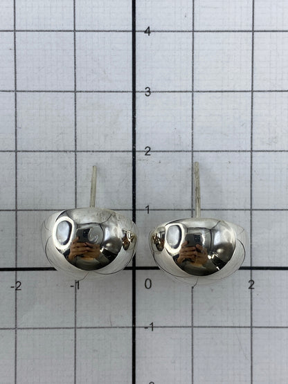 Aretes de plata de Taxco sobre fondo blanco mostrando simetría