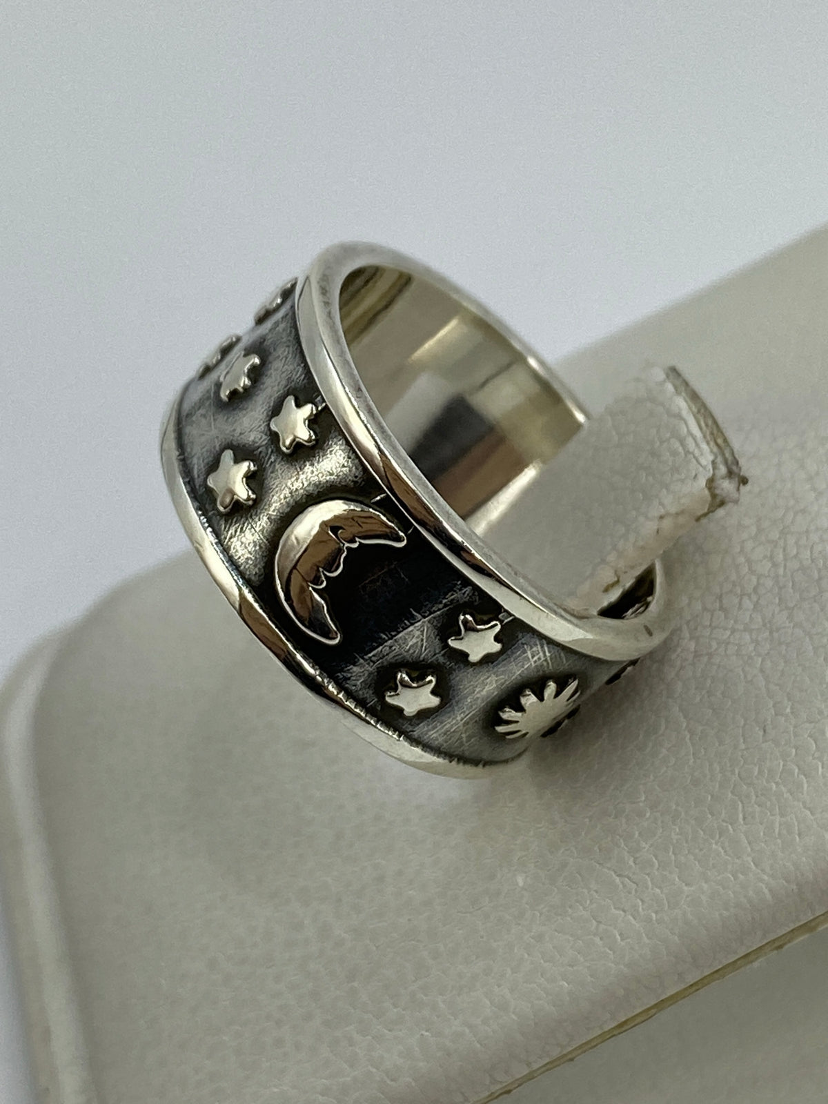 Anillo sobre dedo mostrando el diseño luna y estrellas en relieve
