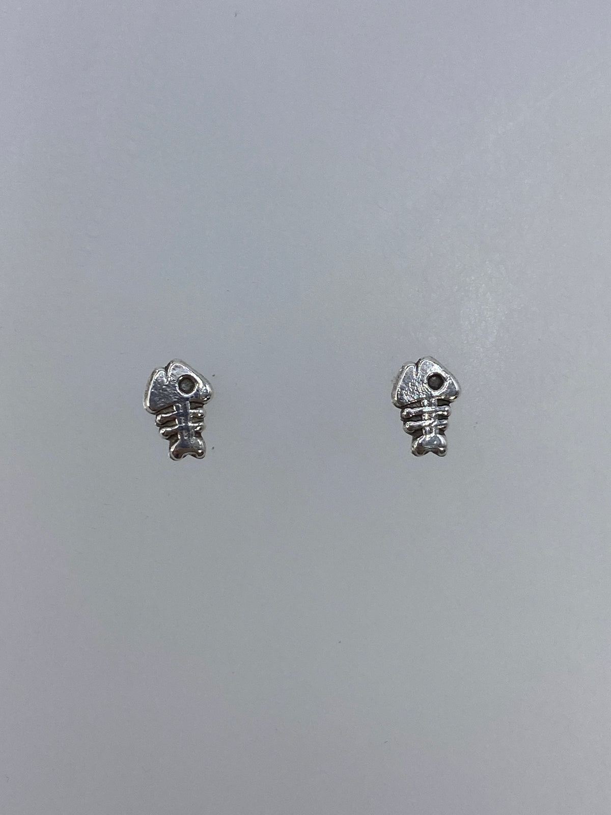 Vista frontal de los aretes de plata de 1 cm con técnica cartoneado y acabado pulido