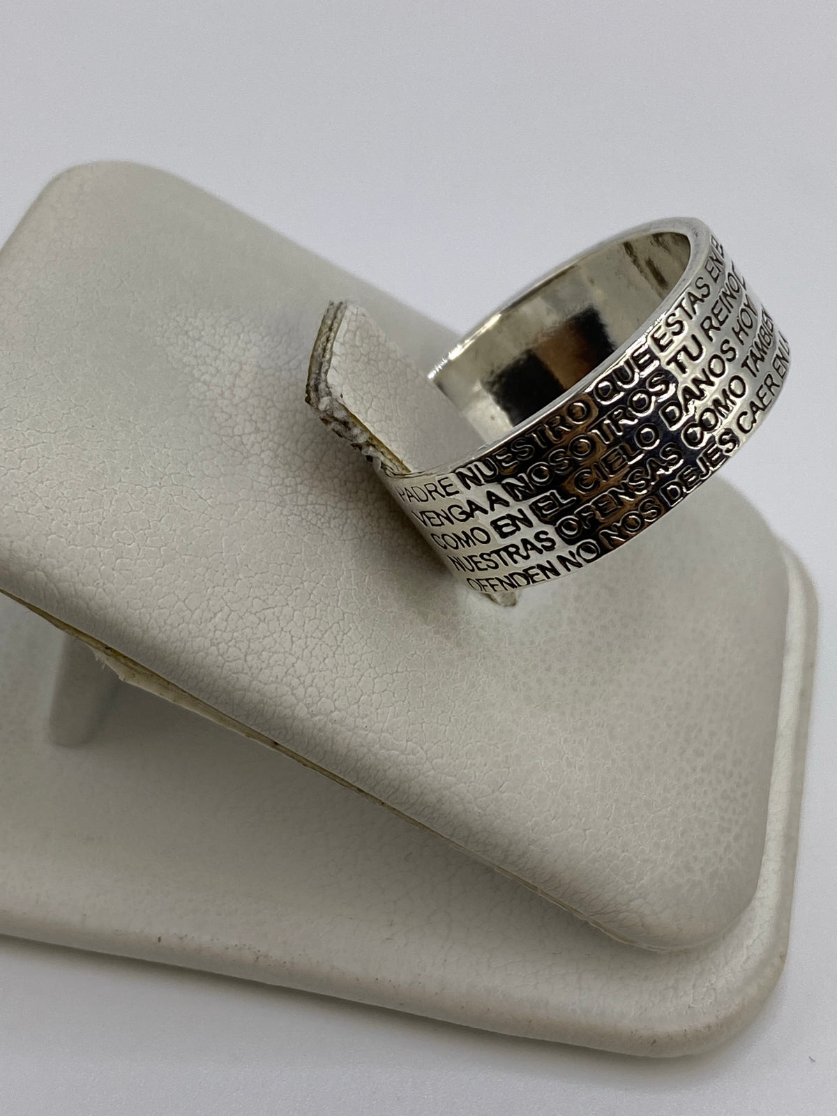 Vista lateral del anillo religioso mostrando el texto grabado en la banda de plata
