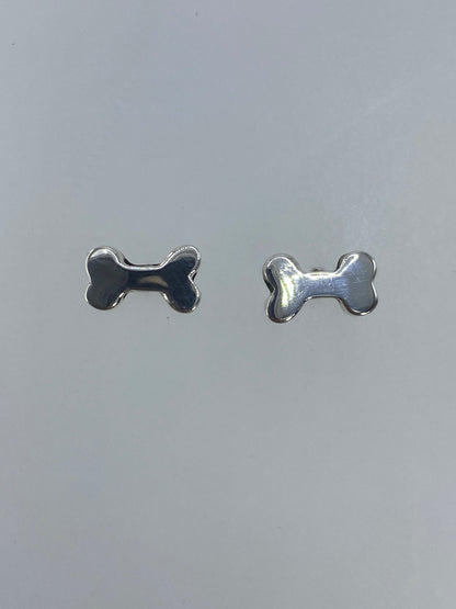 Detalle frontal de los aretes diminutos de cartoneado con acabado pulido