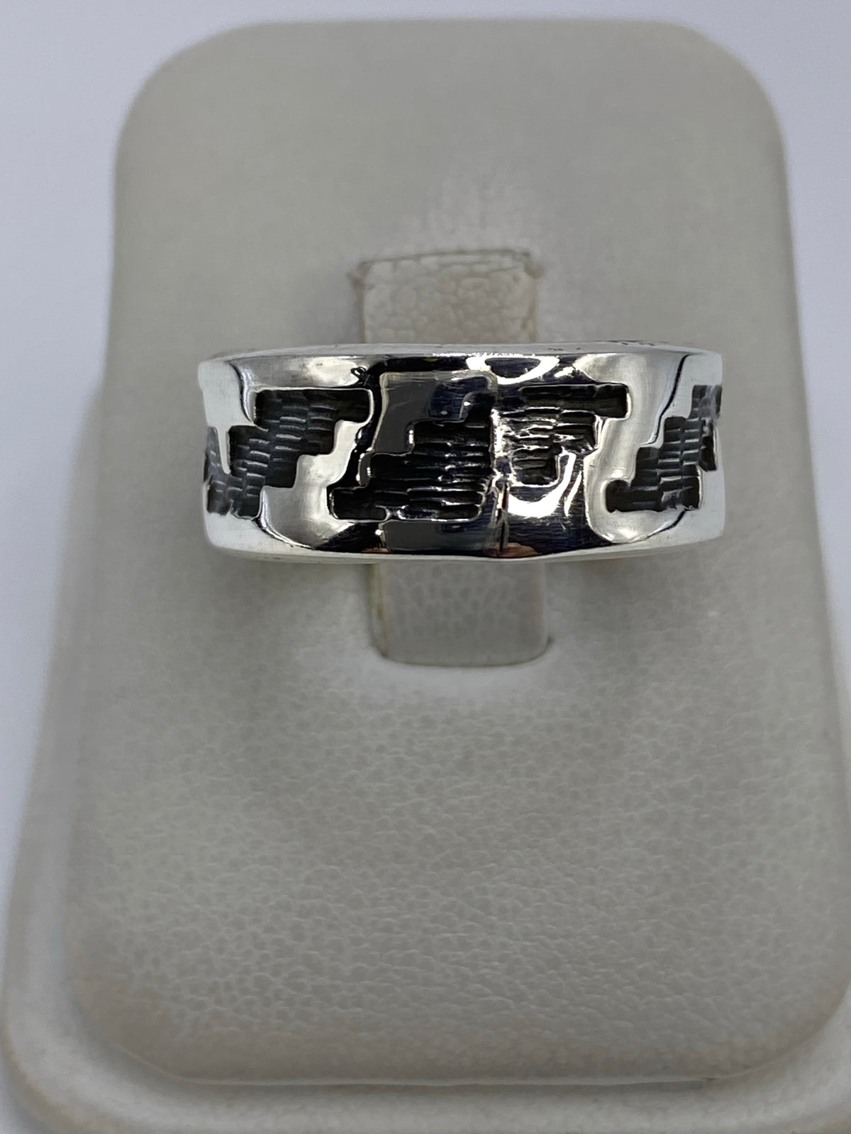 Anillo de plata 925 repujado con diseño geométrico en relieve, visto de frente sobre base blanca